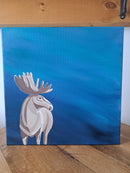 Impressionist Painting of a moose on a blue background, displayed on a wooden surface.